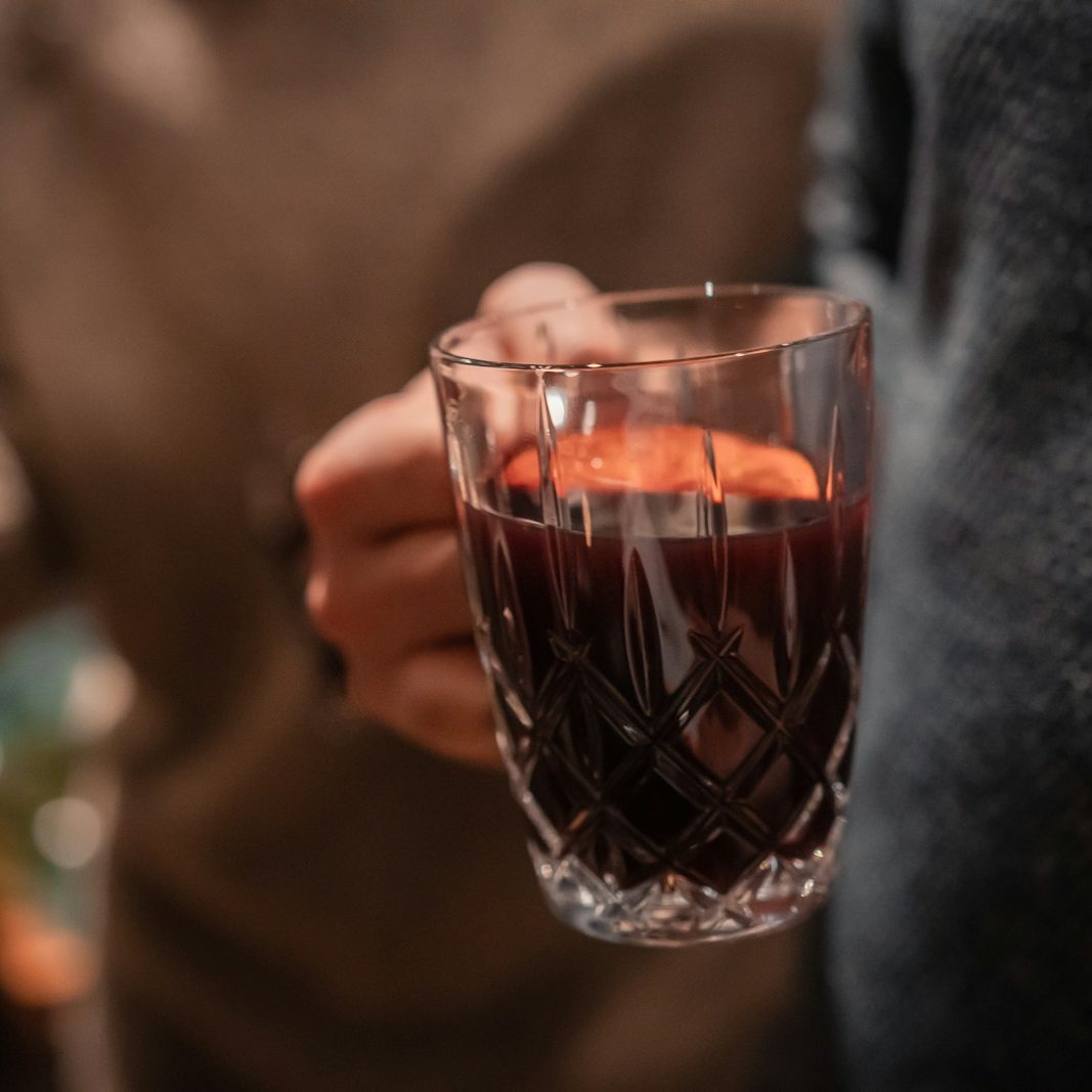 a person holding a wine glass filled with liquid